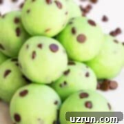 Lucky Green St. Patrick's Day Desserts 12 A beautiful stack of luscious Easy Chocolate Mint Truffles, adorned with mini chocolate chips, presented on a clean white background, highlighting their rich texture.
