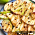 Lucky Green St. Patrick's Day Desserts 13 Easy Homemade Apple Nachos generously topped with peanut butter, almond butter, and chocolate chips, creatively served on a cheerful blue plate, highlighting the fresh green apples.