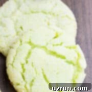 Lucky Green St. Patrick's Day Desserts 9 Close-up of vibrant Easy Key Lime Crinkle Cookies on a rustic wood background, perfectly showcasing their characteristic sugary cracks and bright green hue, inviting a taste.
