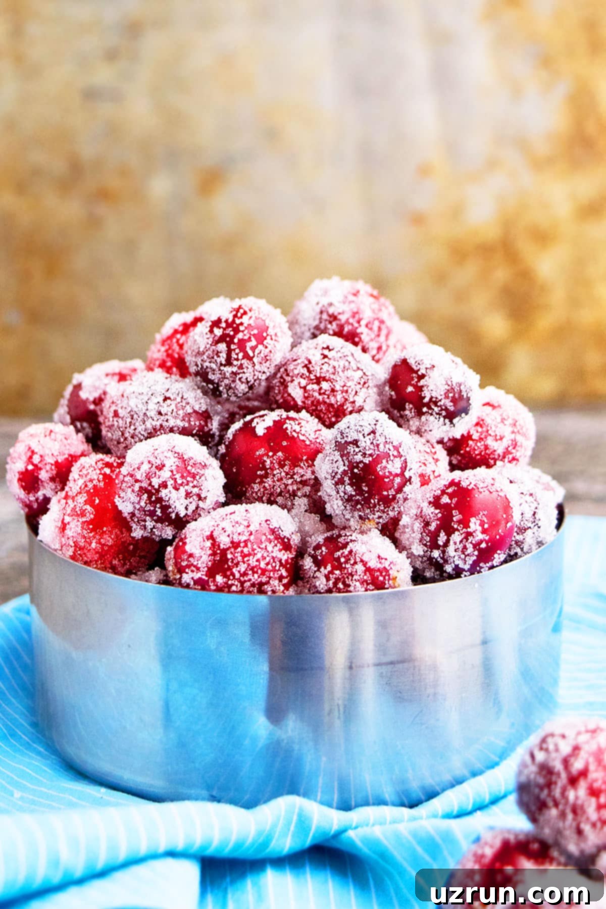 Easy Sugared Cranberries in Metallic Bowl on Blue Cloth. 