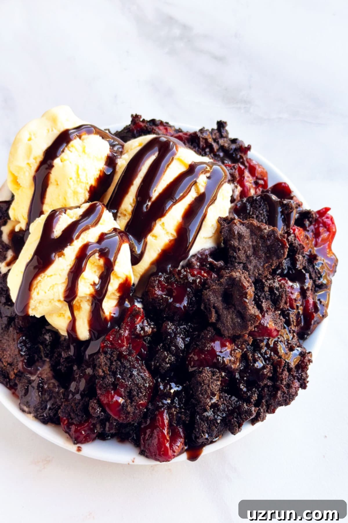 Easy Chocolate Cherry Dump Cake With Cake Mix Topped With Ice Cream on White Dish 
