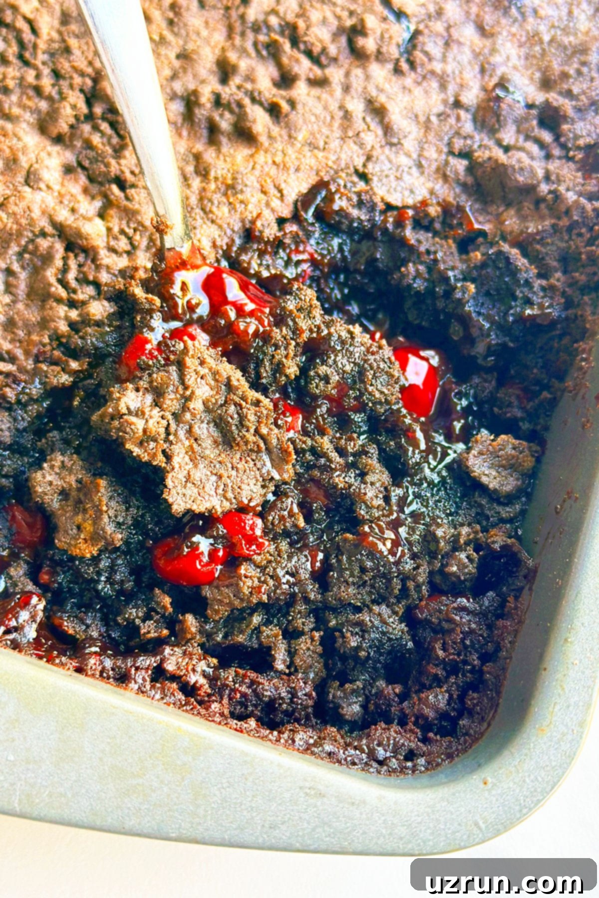 Effortless Chocolate Cherry Dump Cake 5 Spoonful of Cherry Dump Cake in Baking Pan- Closeup Shot