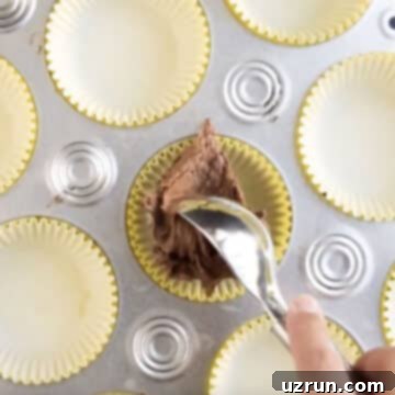 Fluffy Sugar-Free Chocolate Cupcakes 10 Adding spoonful of batter in cupcake liner.