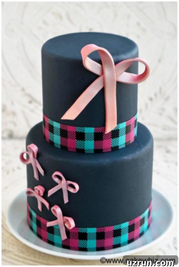 Tiered Gray Cake Decorated With Pink Fondant Bows, Placed on a White Plate