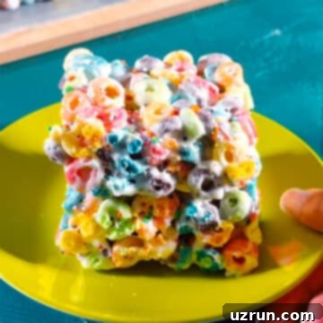 Three-Ingredient Rainbow Cereal Bars 12 Slices of chilled bars on green dish.