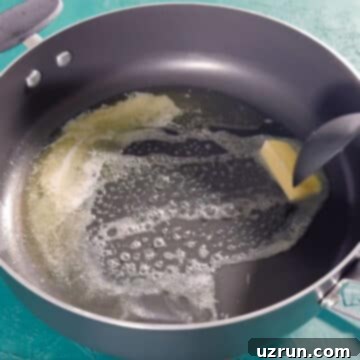 Three-Ingredient Rainbow Cereal Bars 5 Butter being heated in a large nonstick pot.