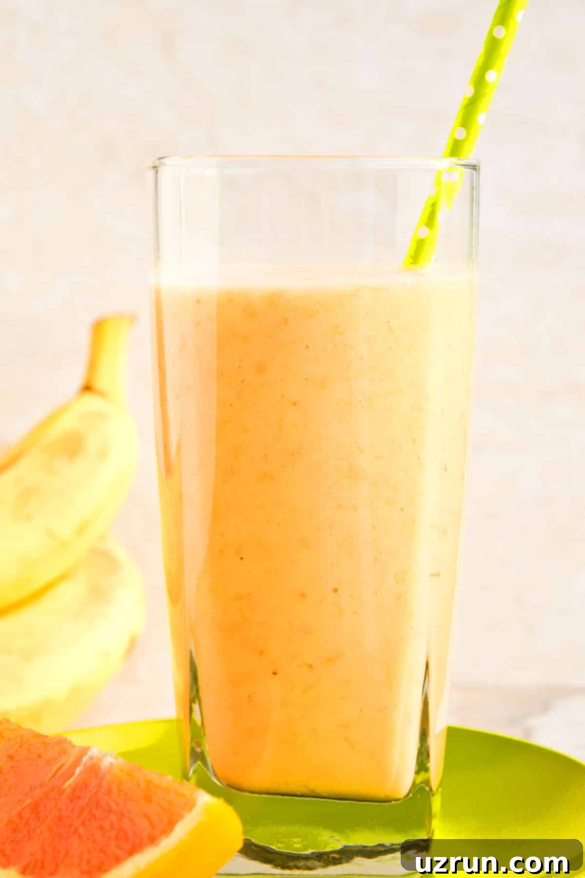 Sunshine Mango Trio Smoothie 2 Easy Orange Banana Mango Smoothie in Glass Cup With Green Polka Dot Straw.