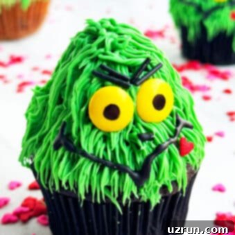 Easy Grinch Cupcakes with Buttercream Icing 7 Easy Grinch Cupcakes Decorated With Buttercream Icing on White Marble Background.