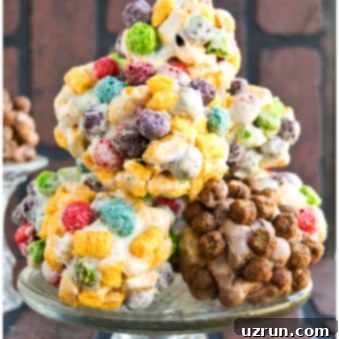 No-Bake Rainbow Cereal Balls 8 Stack of Easy Homemade Rainbow Cereal Balls on Glass Cake Stand
