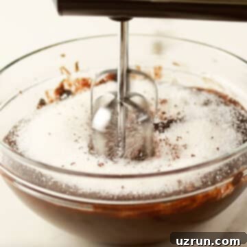 Fudgy Chocolate Orange Brownies 4 Melted chocolate mixture and sugar being mixed with a hand-held mixer.