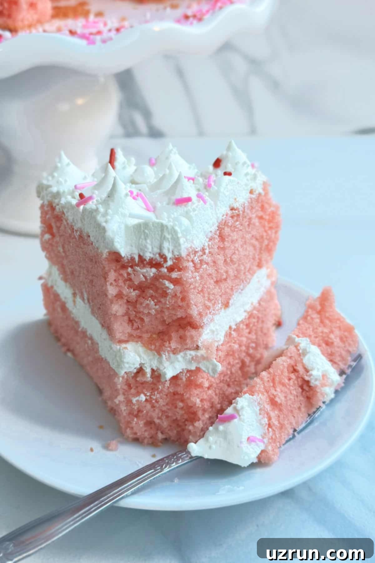 Easy Strawberry Pink Champagne Cake 4 Partially Eaten Cake With Fork Full on White Dish.