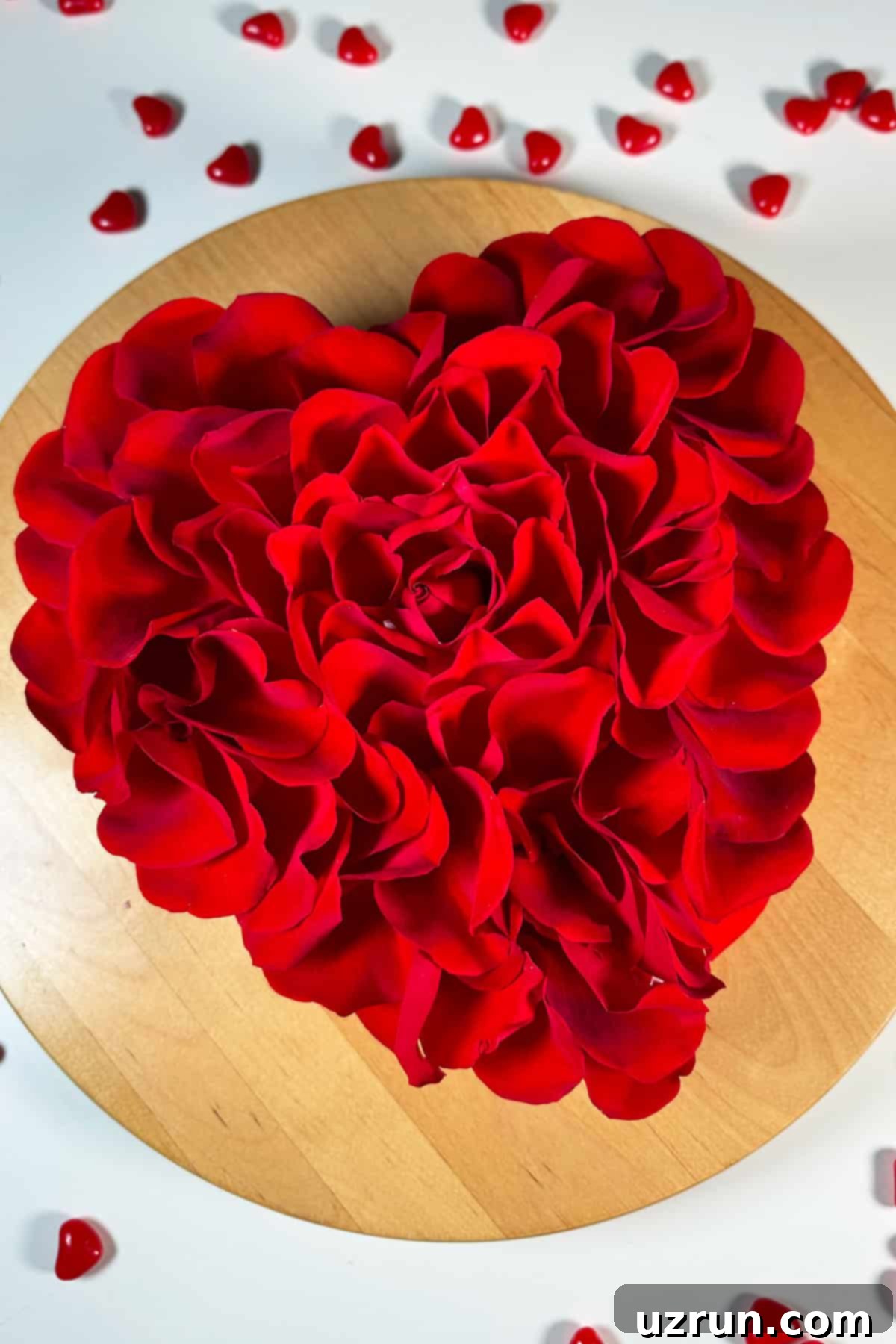 Fragrant Red Rose Cake with Rose Water 3 Homemade Cake with Fresh Flower Petals on Wood Cake Stand. A delightful red rose cake, heart-shaped, adorned with fresh petals and ready for serving.