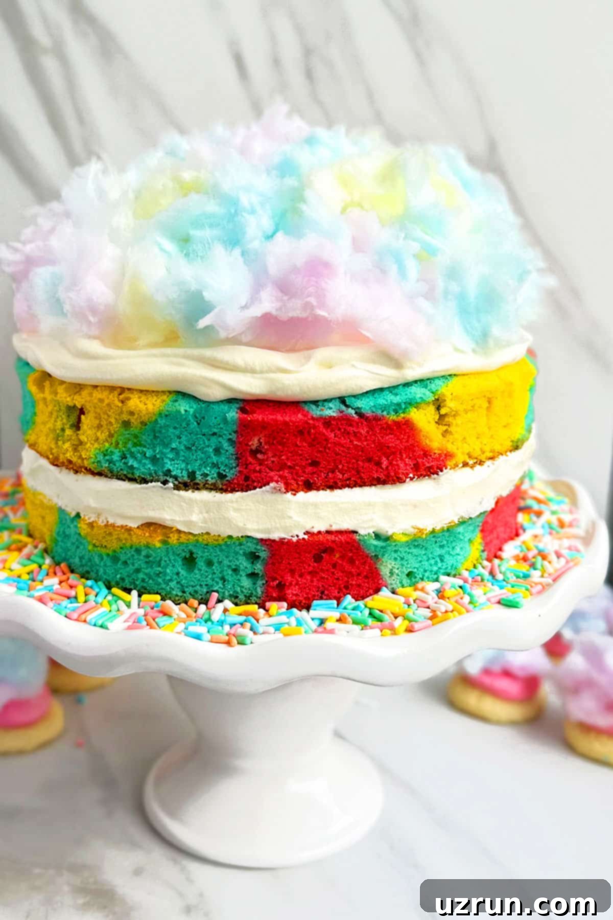 Easy Cotton Candy Cake With Whipped Cream Frosting on White Cake Stand.