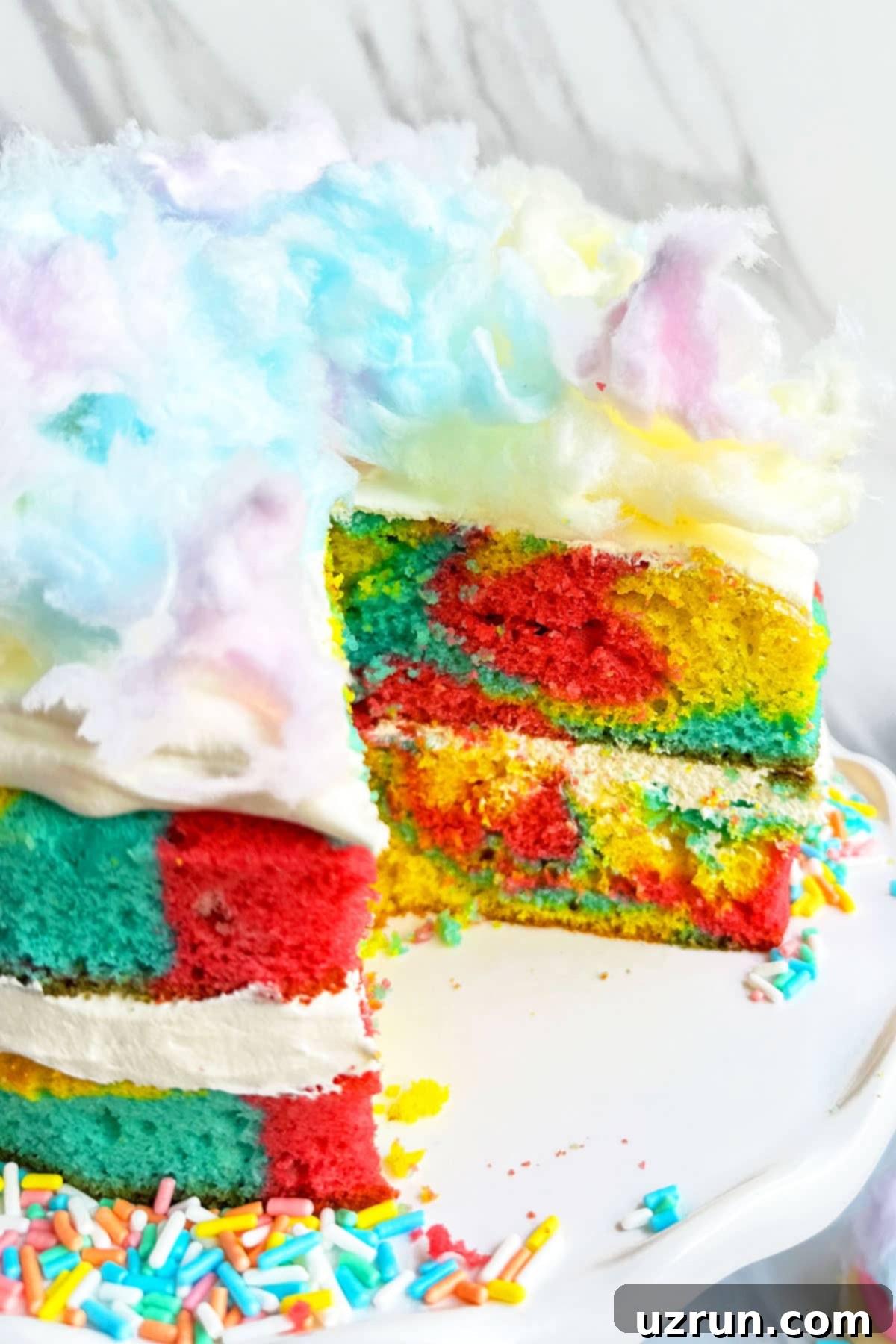 Whimsical Cake Mix Cotton Candy Cake 6 Cake on White Cake Stand With One Slice Removed.