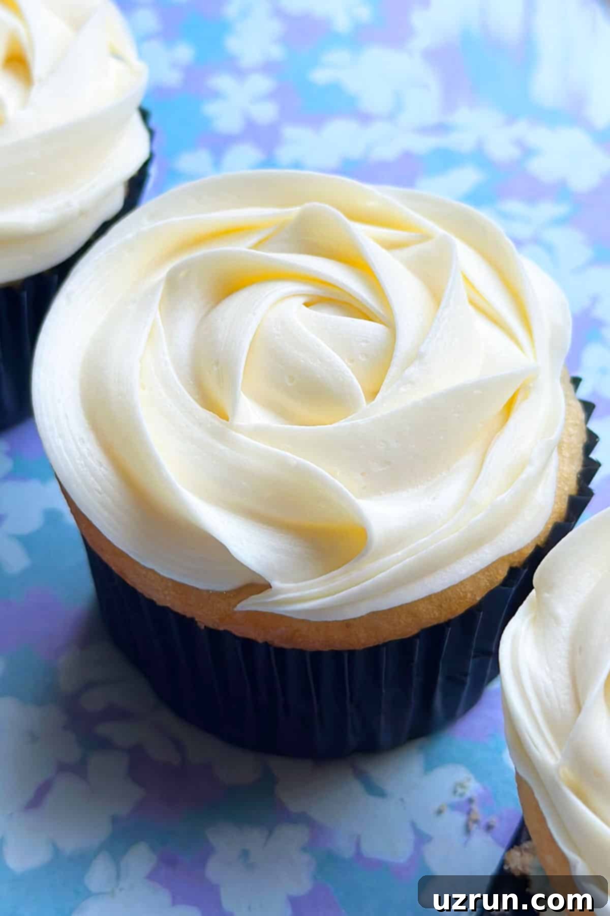 Easy Almond Buttercream Frosting 2 Easy Almond Buttercream Frosting Piped on Top of Cupcake on Blue Background.