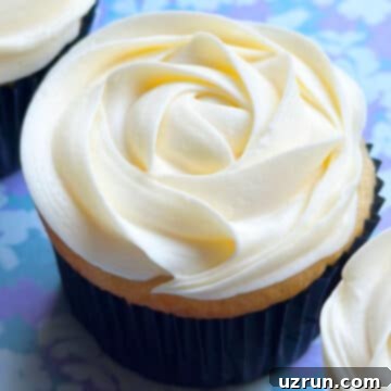 Easy Almond Buttercream Frosting 5 Easy Almond Buttercream Frosting Piped on Top of Cupcake on Blue Background.