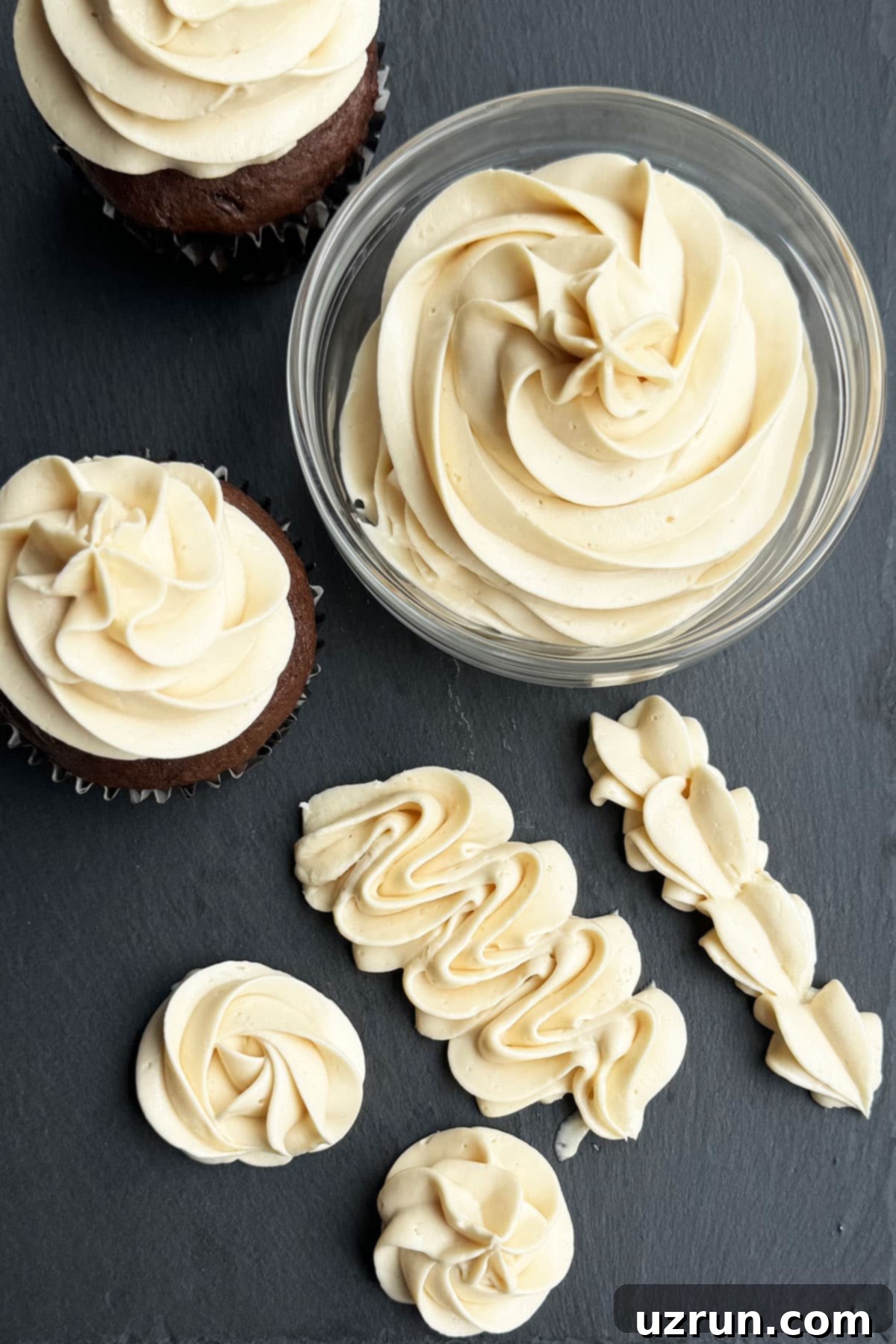 Honey Frosting: Simply Sweet, No Powdered Sugar 3 Piped frosting designs, iced cupcakes and bowl of buttercream on Gray Stone Background.
