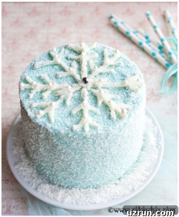 Easy Snowflake Cake Decorated with White Chocolate and Sparkling Sugar on a White Cake Stand, ready to serve.