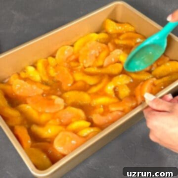 Easy Cake Mix Apple Dump Cake 4 Apple pie filling being spread in a rectangle baking pan.