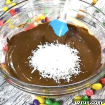 Easy No-Bake Chocolate Haystacks 6 Shredded coconut added to chocolate mixture in glass bowl.