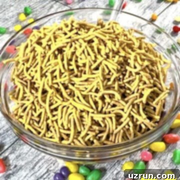 Easy No-Bake Chocolate Haystacks 7 Chow mein noodles added to chocolate mixture in glass bowl.