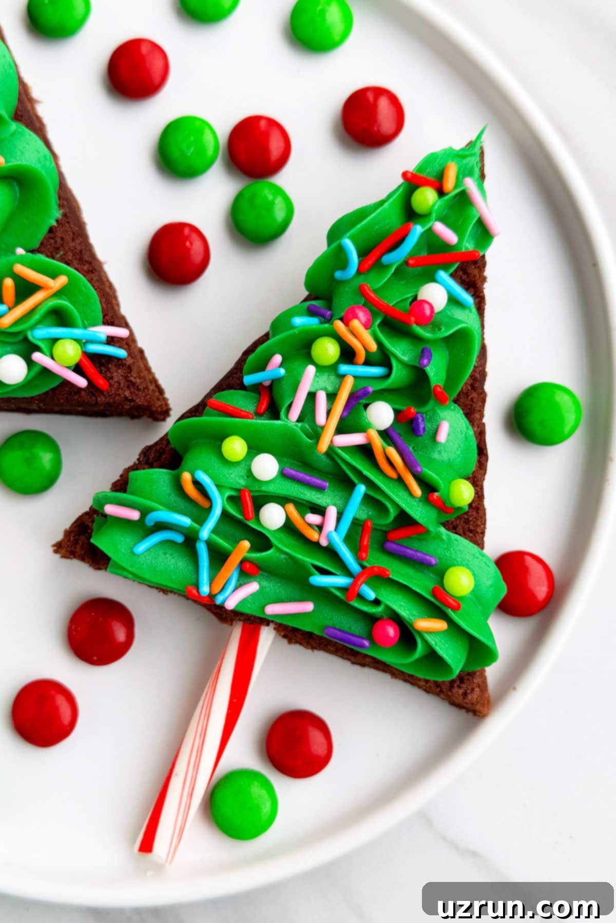 Easy Christmas Tree Brownies With Buttercream Frosting and Sprinkles on White Dish.