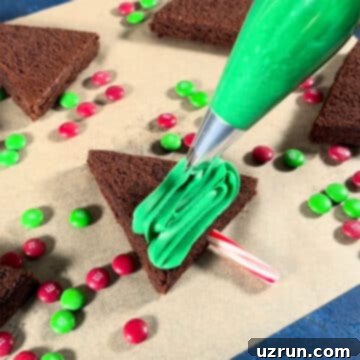 Christmas Tree Brownie Bites 7 Green frosting being piped on top of brownie.