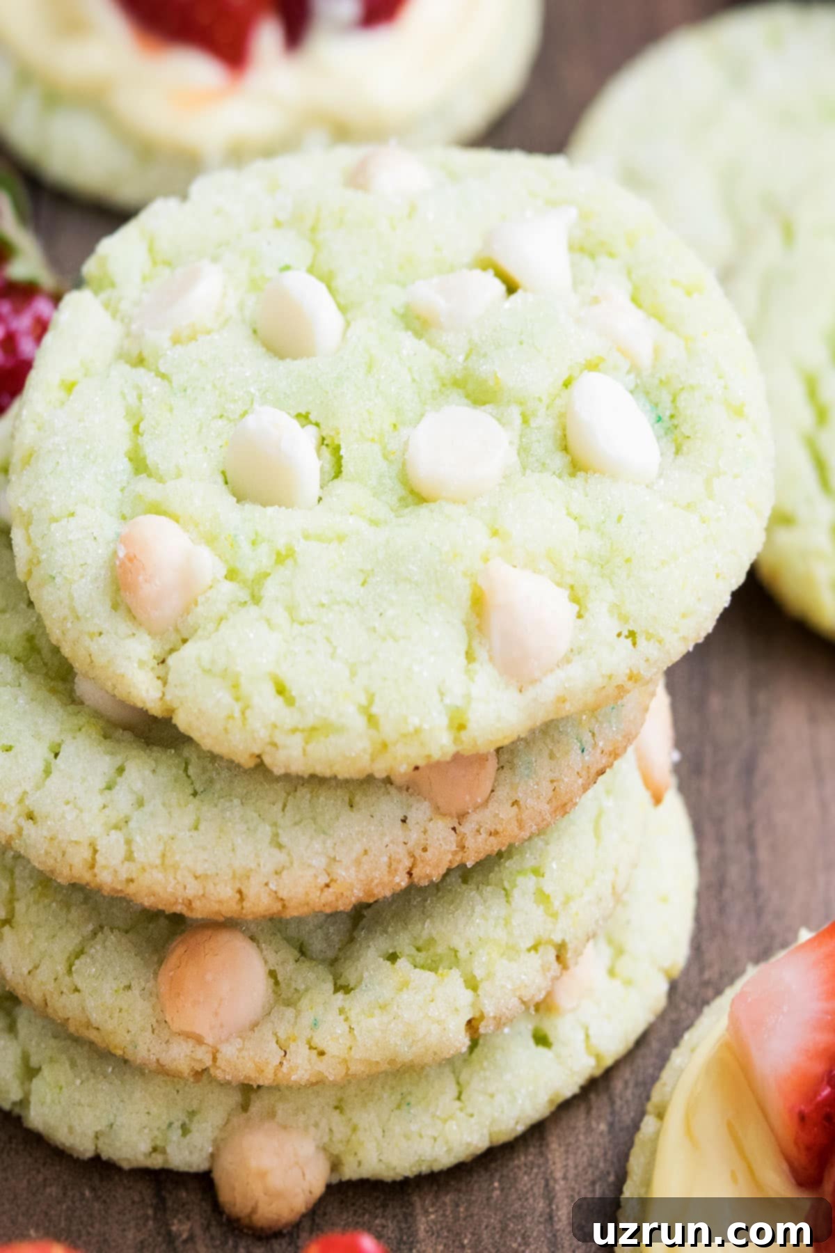 Zesty Key Lime Crinkle Cookies 3 Stack of Crinkle Cookies With White Chocolate Chips on Wood Background.