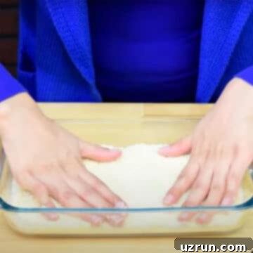 Chocolate Coconut Macaroon Bars 5 Spreading Coconut Mixture Layer in Glass Dish and Pressing Down With Hands to create a firm base.