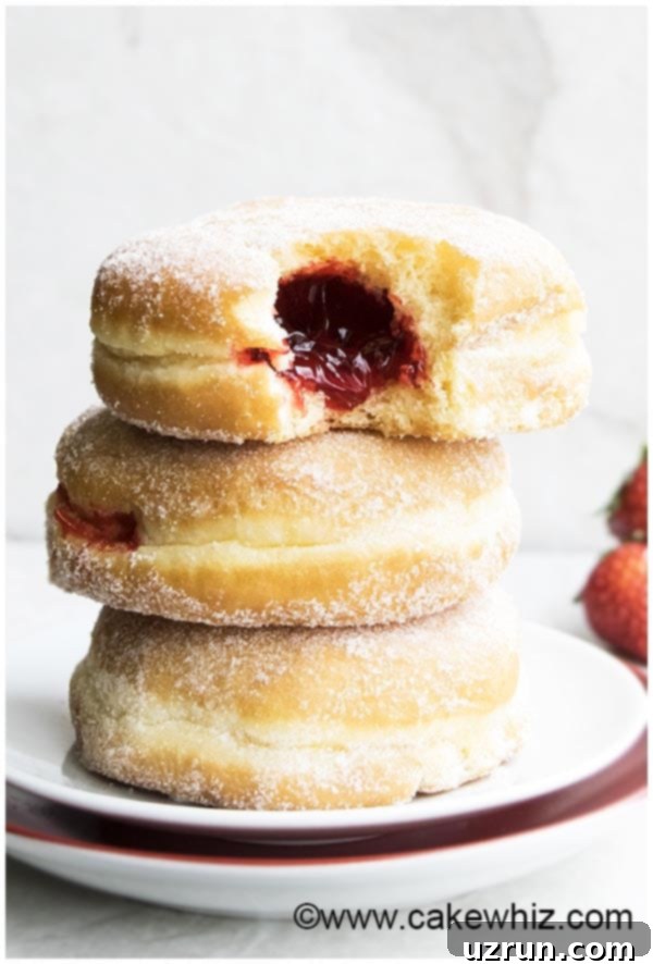 Homemade Jelly Filled Donuts Stacked on a White Dish, ready to be enjoyed