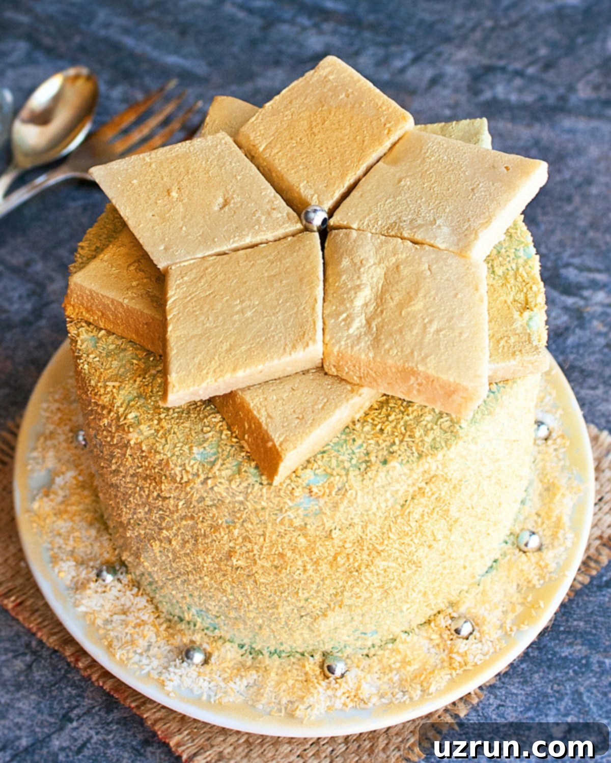 Easy Cake Decorating Ideas for Beginners 20 A cake decorated with geometric pieces of halva, highlighted with gold edible spray for a luxurious look.