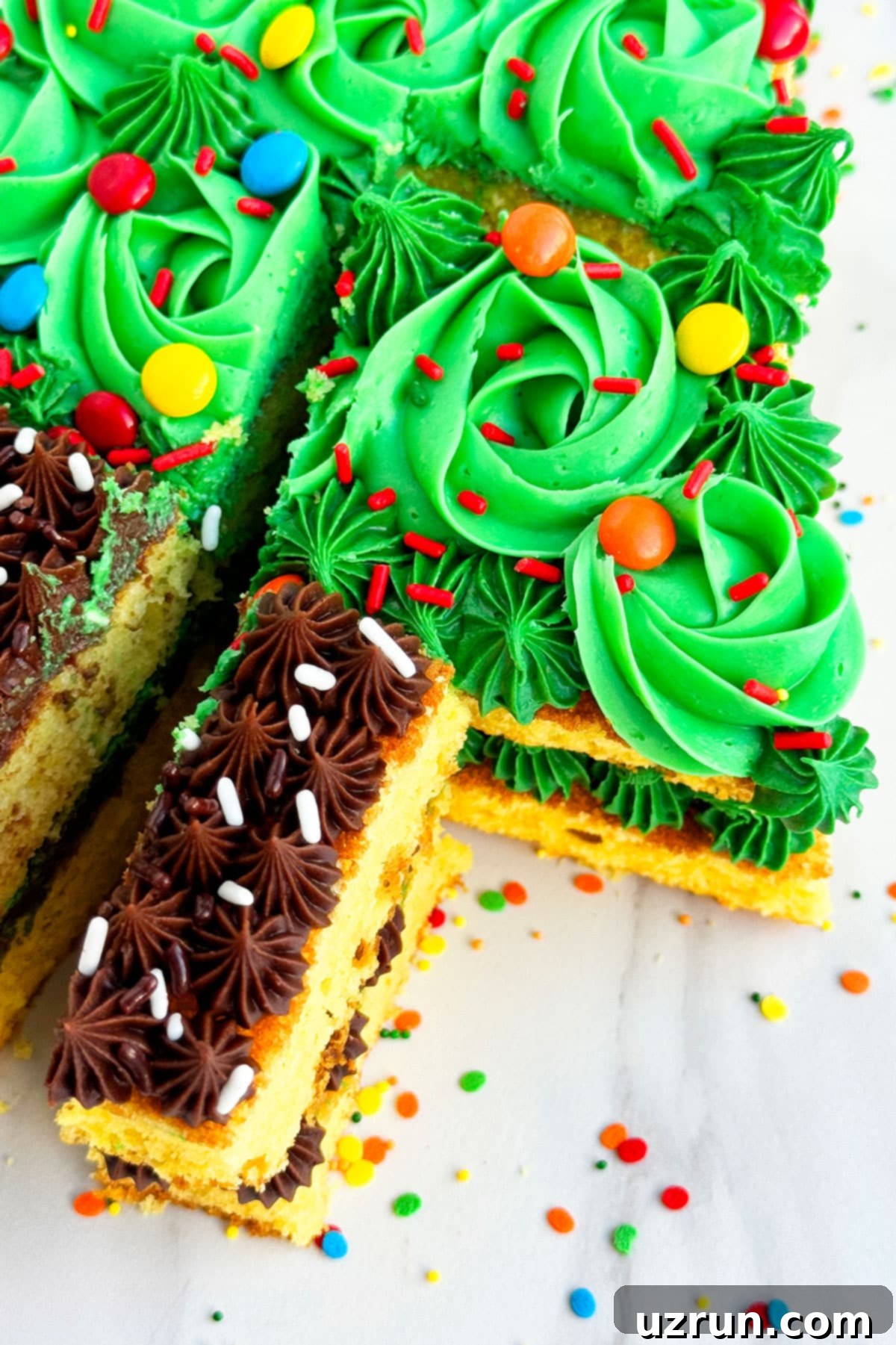 Easy Christmas Tree Cake 6 Slice of Yellow Cake With Icing on Marble Background.