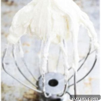 The Best Stable Cream Cheese Frosting 6 Stable Best Cream Cheese Frosting on Whisk on Rustic Metallic Background