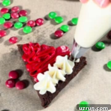 Christmas Santa Hat Brownie Bites 7 Piping white buttercream frosting stars on the bottom empty strip of a triangle brownie, creating the hat's brim.