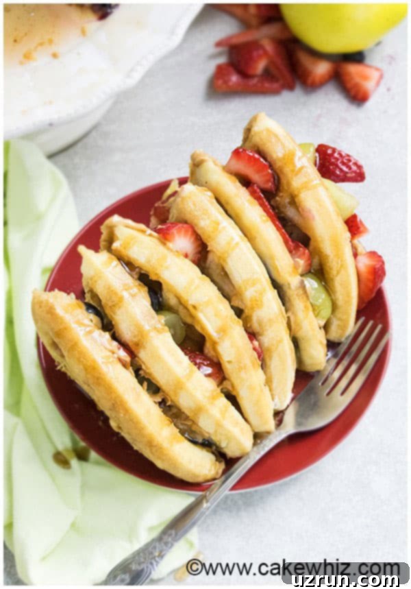 Waffle Cake Made Easy 4 Slice of Breakfast Cake on Red Dish With Fork, showing the layers of waffle, filling, and fruit.