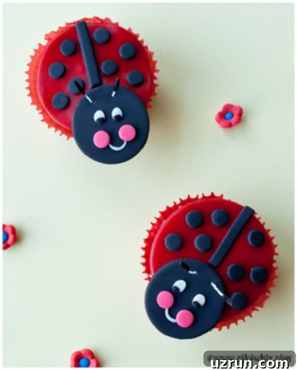 Two decorated ladybug cupcakes on a vibrant yellow background, showcasing the red and black fondant details for kids' birthday parties.