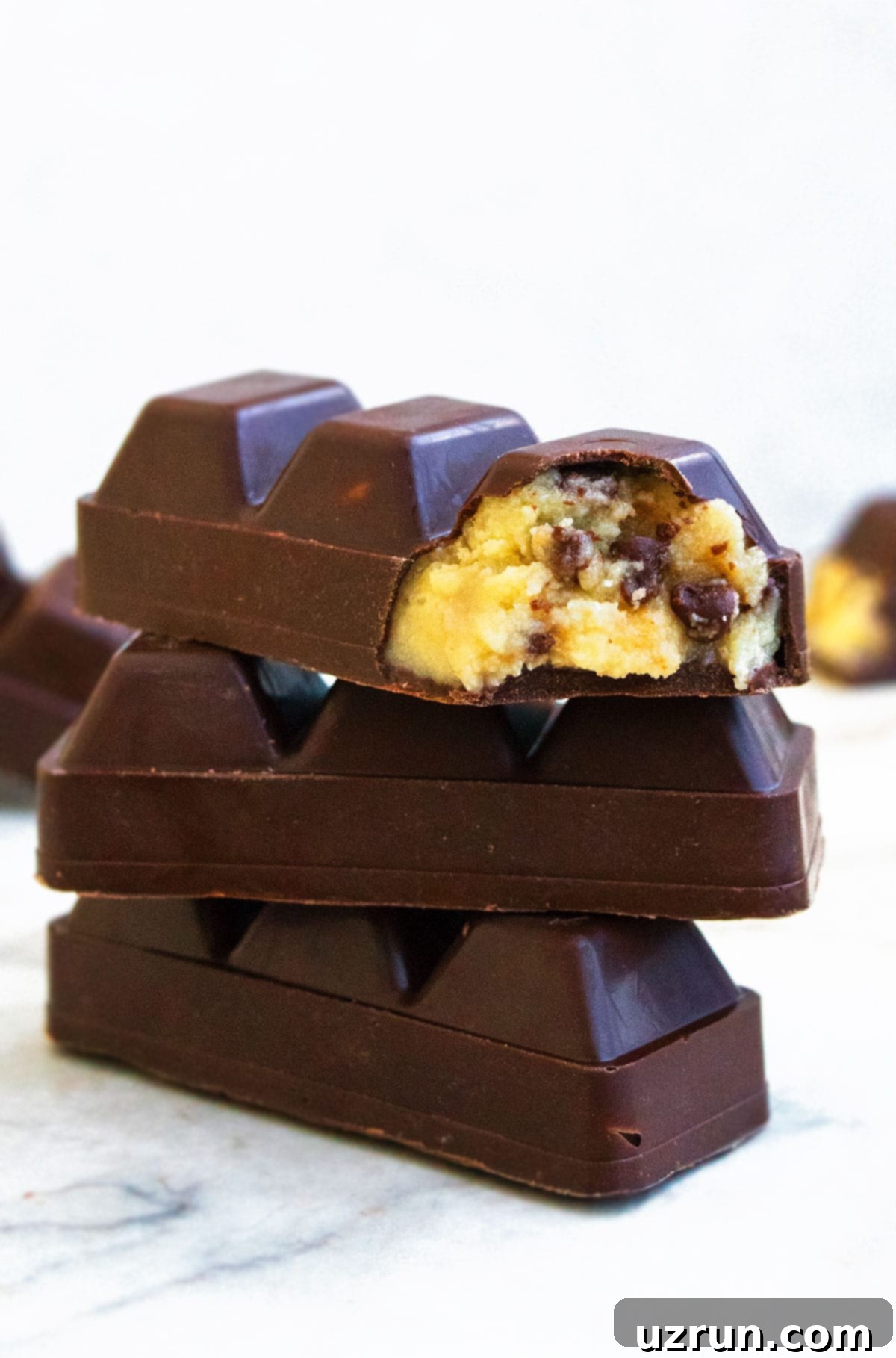 Stack of Easy Homemade Eggless Chocolate Chip Cookie Dough Bars on White Marble Background. 