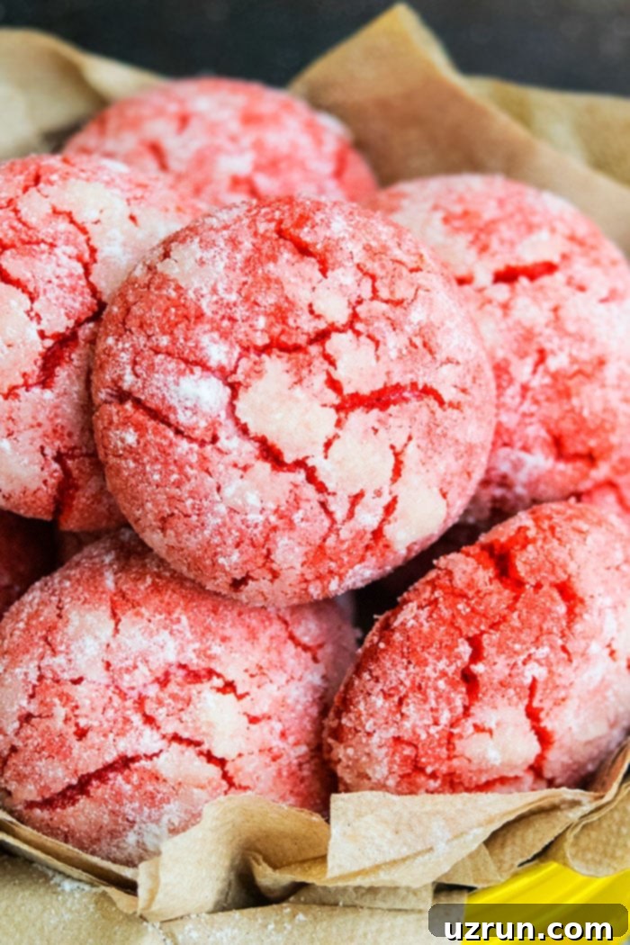 Easy homemade red velvet crinkle cookies in a yellow bowl, showcasing their vibrant color and powdered sugar topping.