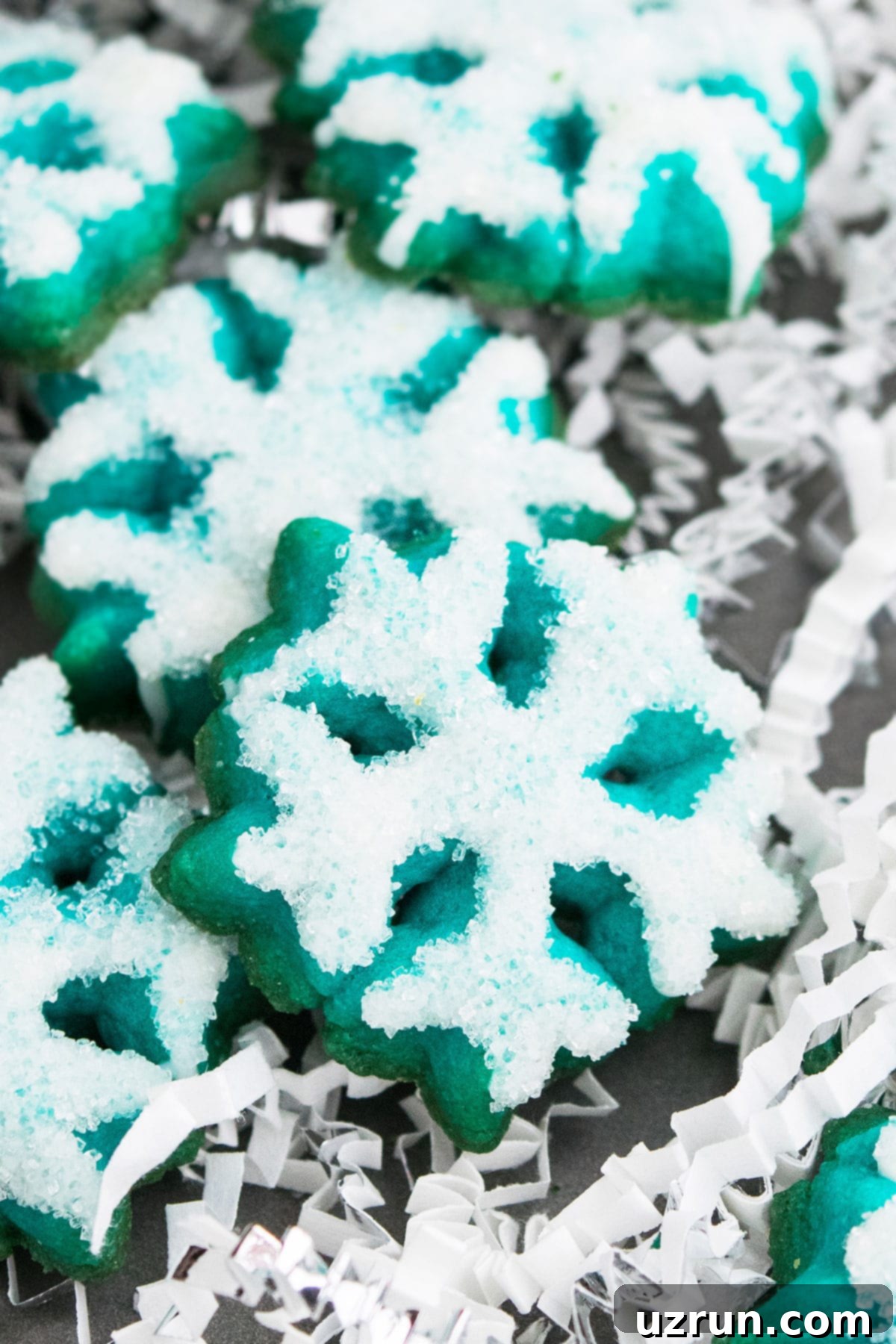 Irresistible Almond Butter Spritz Cookies 4 Blue Snowflake Cookies With Sparkling Sugar Made With Cookie Press on Metal Baking Tray.