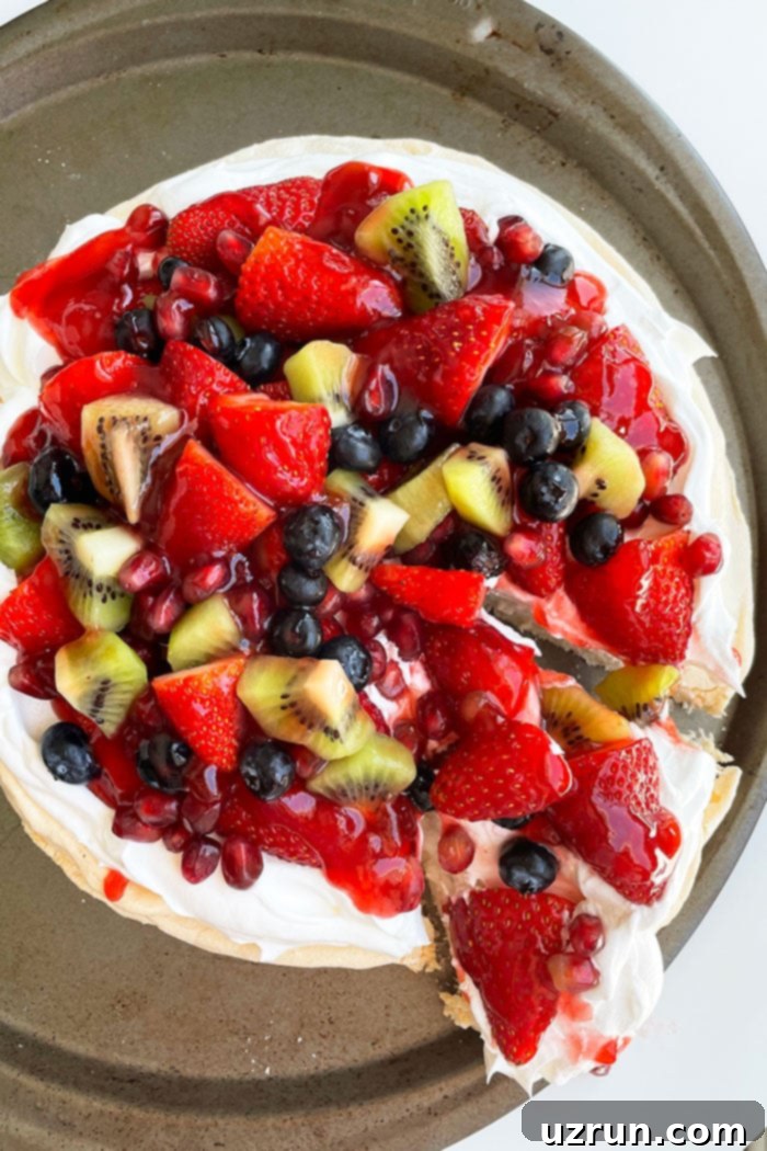 Whip Up a Dreamy Pavlova 4 Round Meringue Dessert with a Slice Partially Removed- Overhead Shot