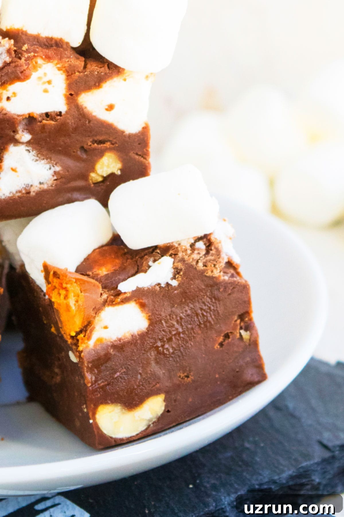 No-Bake Rocky Road Fudge 13 Slice of Fudge on White Dish.