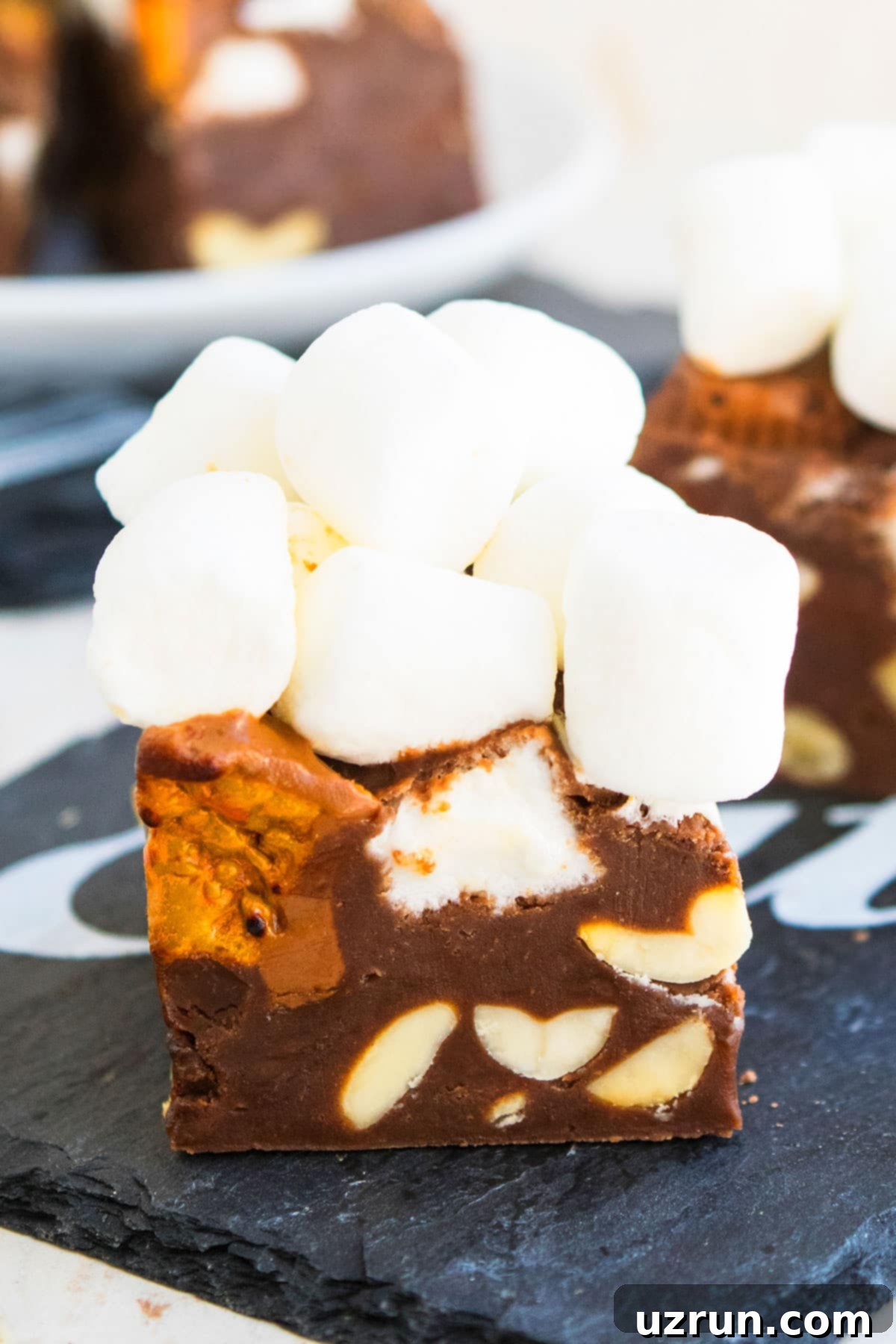 No-Bake Rocky Road Fudge 3 Closeup Shot of Homemade Fudge With Chocolate, Peanut and Marshmallows on Black Dish.
