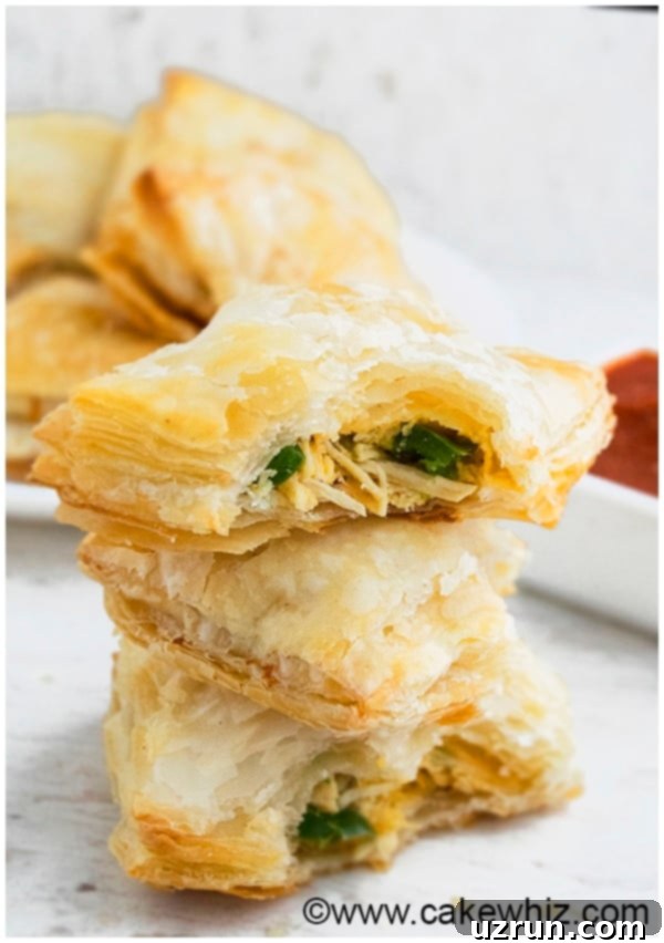 Golden brown jalapeno chicken puffs arranged on a wooden board, showcasing their flaky pastry and appealing golden color.