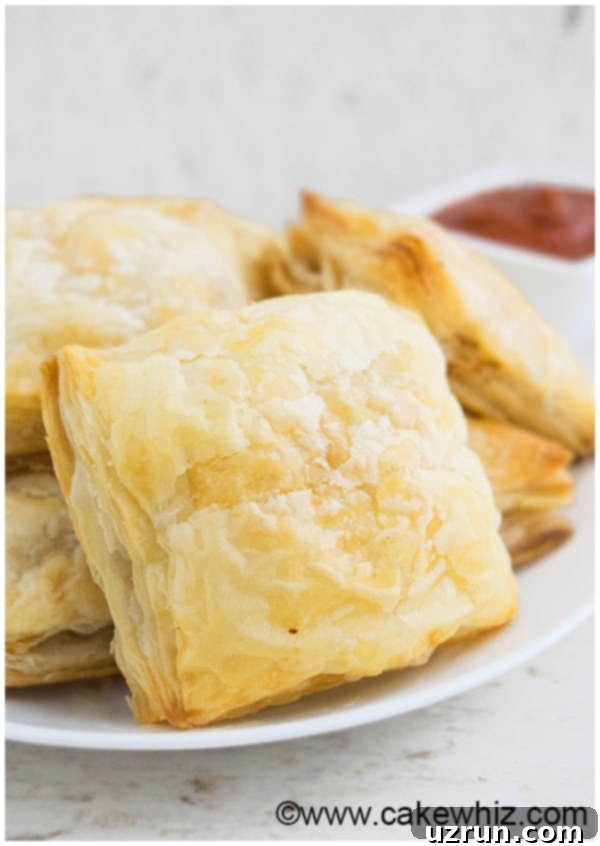 Several golden jalapeno chicken puffs cooling on a wire rack, with some having a slight garnish.