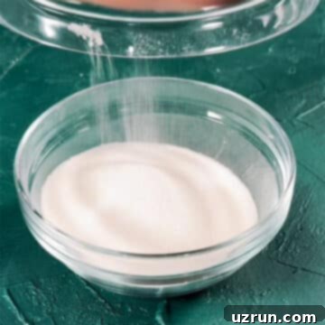 Effortless Homemade Cinnamon Sugar 4 Granulated sugar being added to glass bowl.