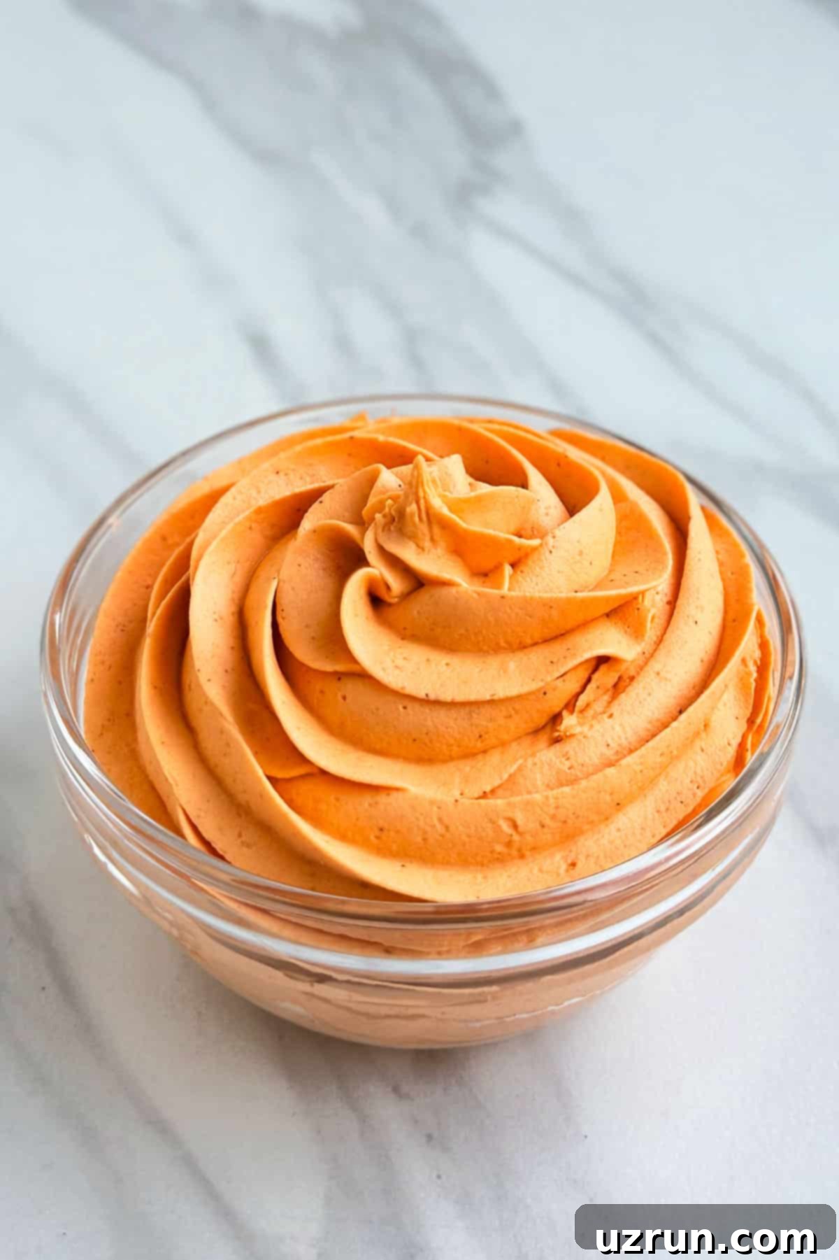 Easy Pumpkin Cream Cheese Frosting 2 Easy Spiced Pumpkin Frosting With Cream Cheese and Pumpkin Puree in Glass Bowl on White Marble Background.