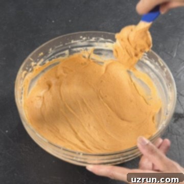 Easy Pumpkin Cream Cheese Frosting 10 Icing in bowl made smooth with spatula.