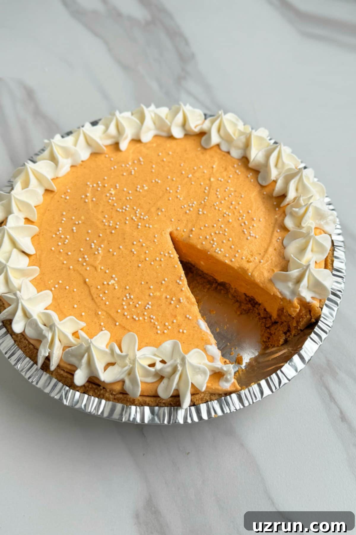 Velvet Pumpkin No-Bake Cheesecake 14 Pie with one slice removed- Closeup Shot.