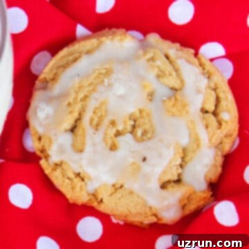 Effortless Soft Chewy Maple Cookies 9 Glazed cookie on red polka dot background.